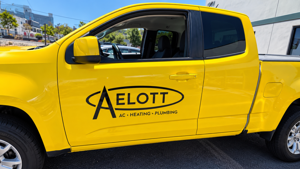 Fleet graphics on a yellow commercial service truck featuring branded business lettering in San Diego