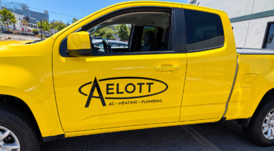 Fleet graphics on a yellow commercial service truck featuring branded business lettering in San Diego