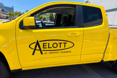 Fleet graphics on a yellow commercial service truck featuring branded business lettering in San Diego